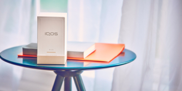 Blond woman opening her gold IQOS device