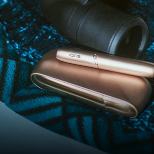 IQOS charger and holder next to binoculars