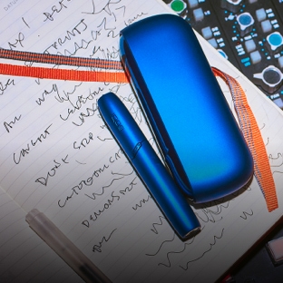 Stellar blue IQOS holder and charger on a note book